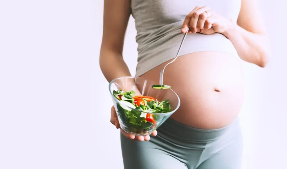 Pregnant woman eating healthy food containing folic acid