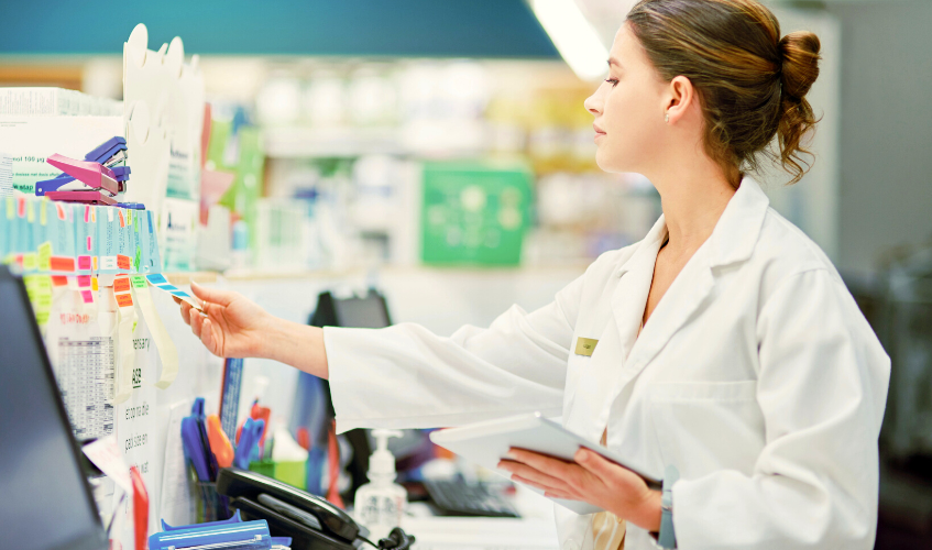 Portrait of a young woman using a digital tablet while working in a pharmacy