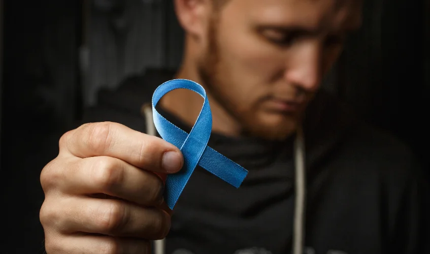Upset young man showing prostate cancer sign